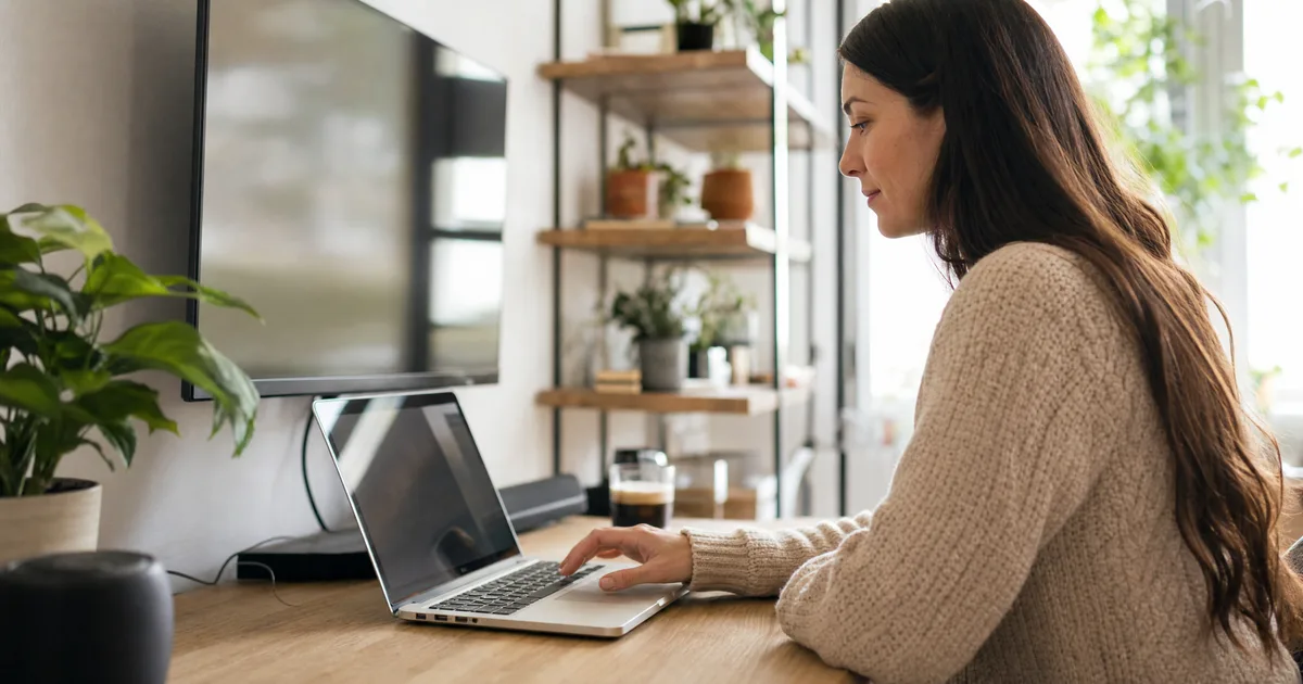 Laptop und Fernseher nebeneinander beim Einrichten der Mediathek im hellen Raum
